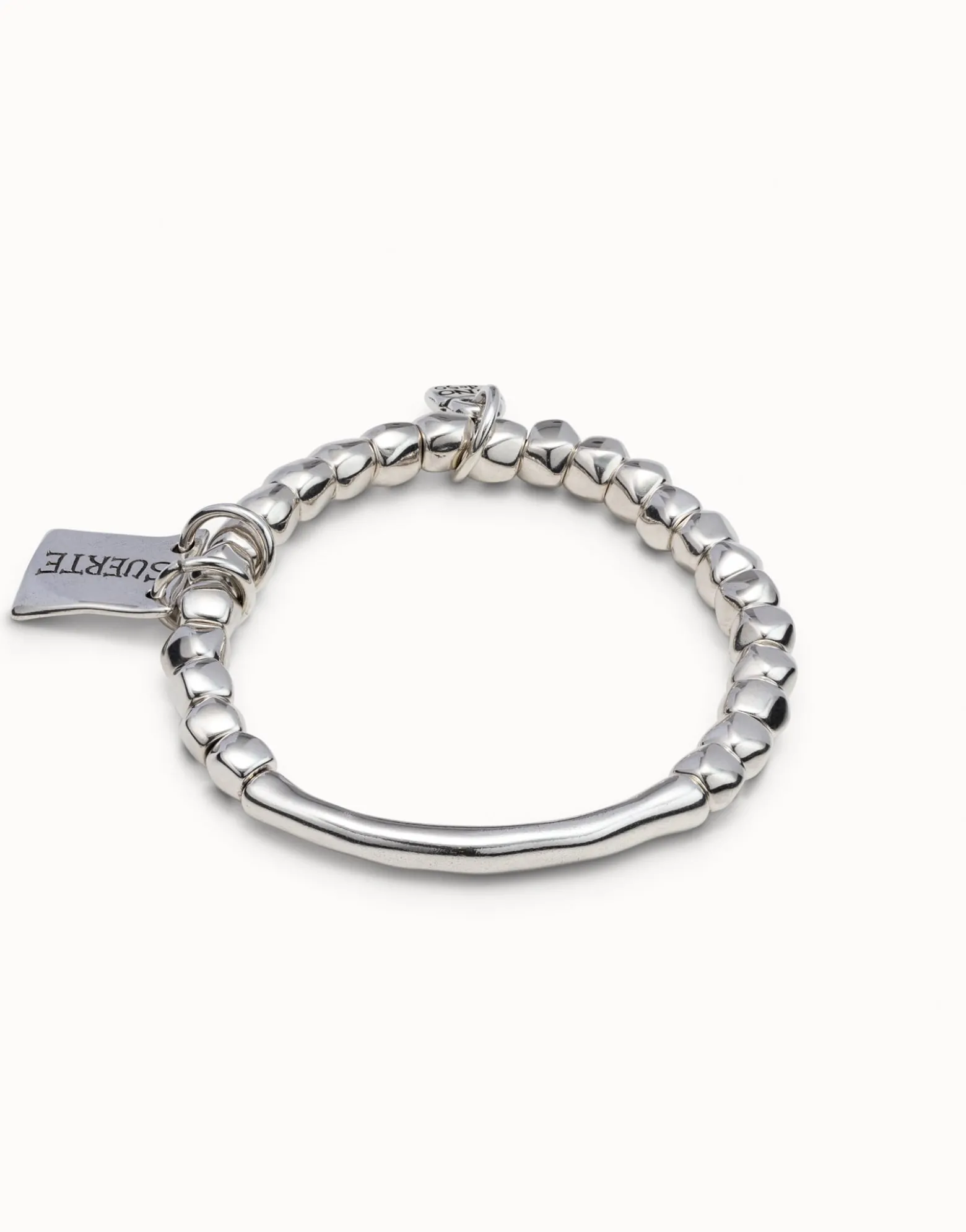 Beaded stretch bracelet with tubular piece and a charm