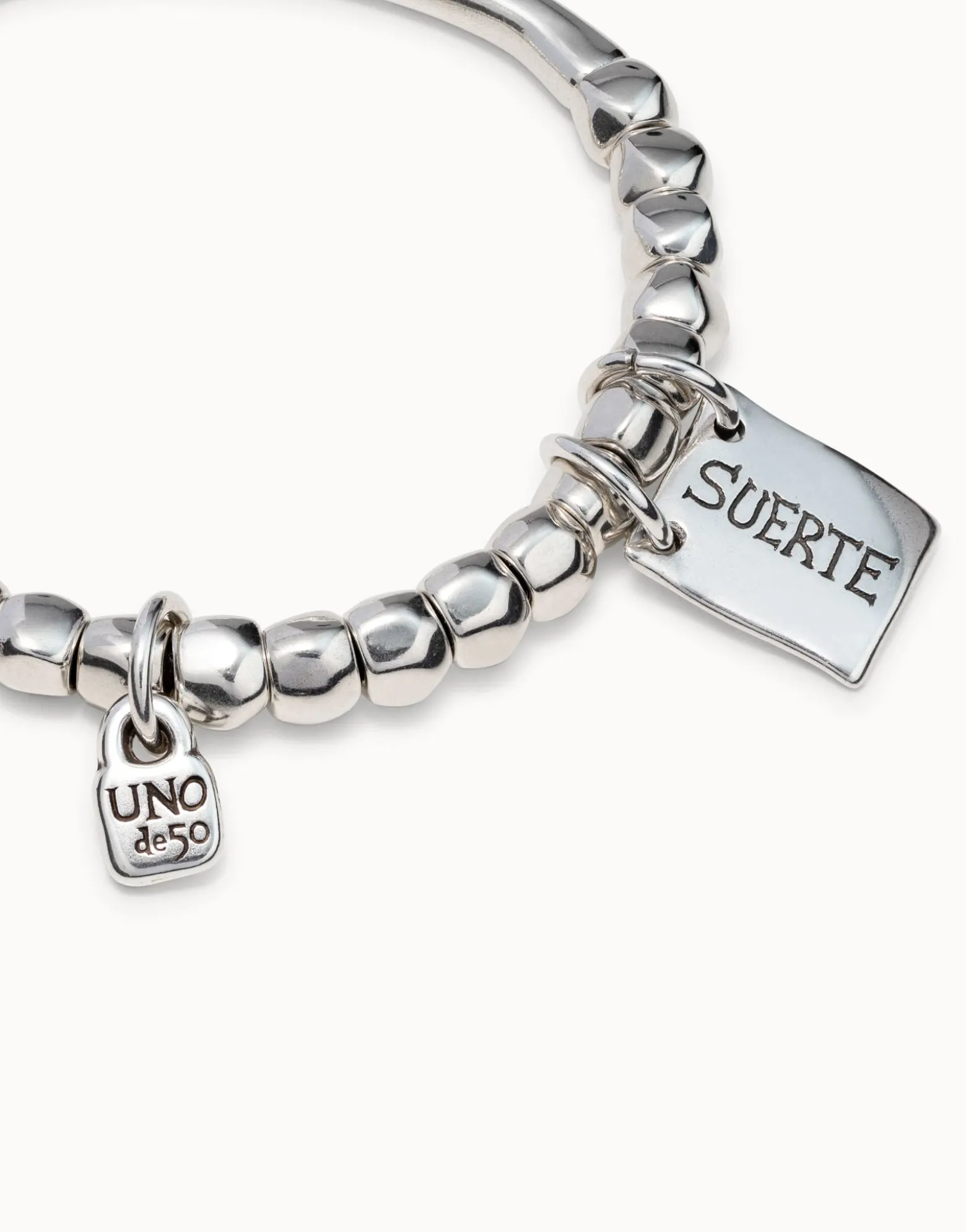 Beaded stretch bracelet with tubular piece and a charm