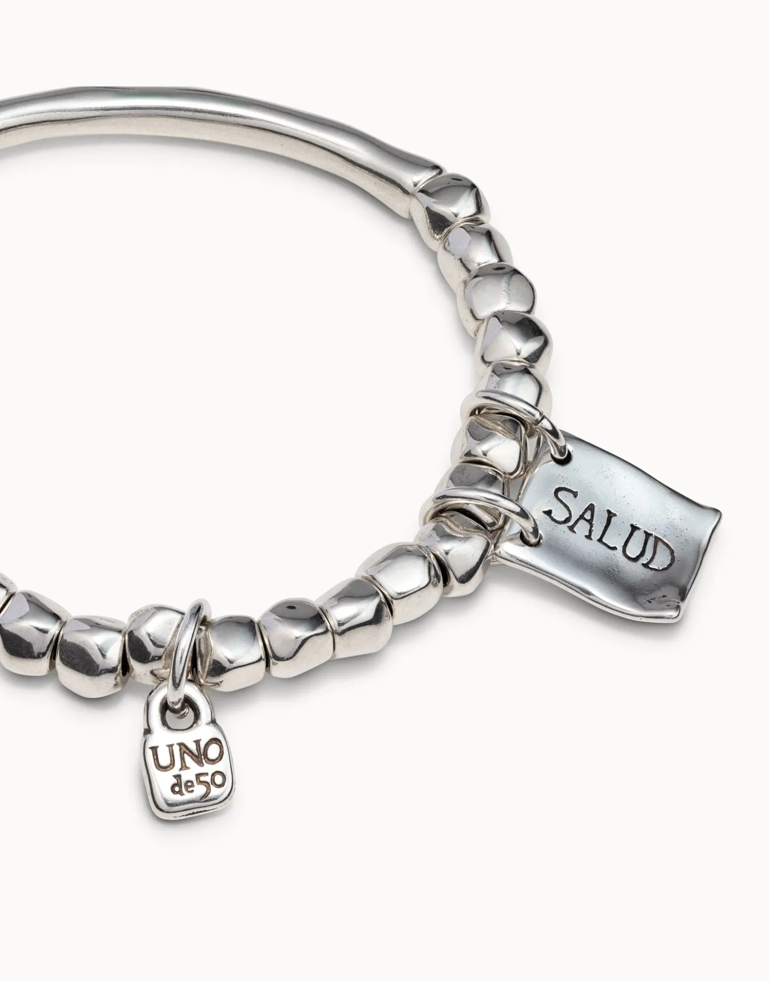 Beaded stretch bracelet with tubular piece and charms
