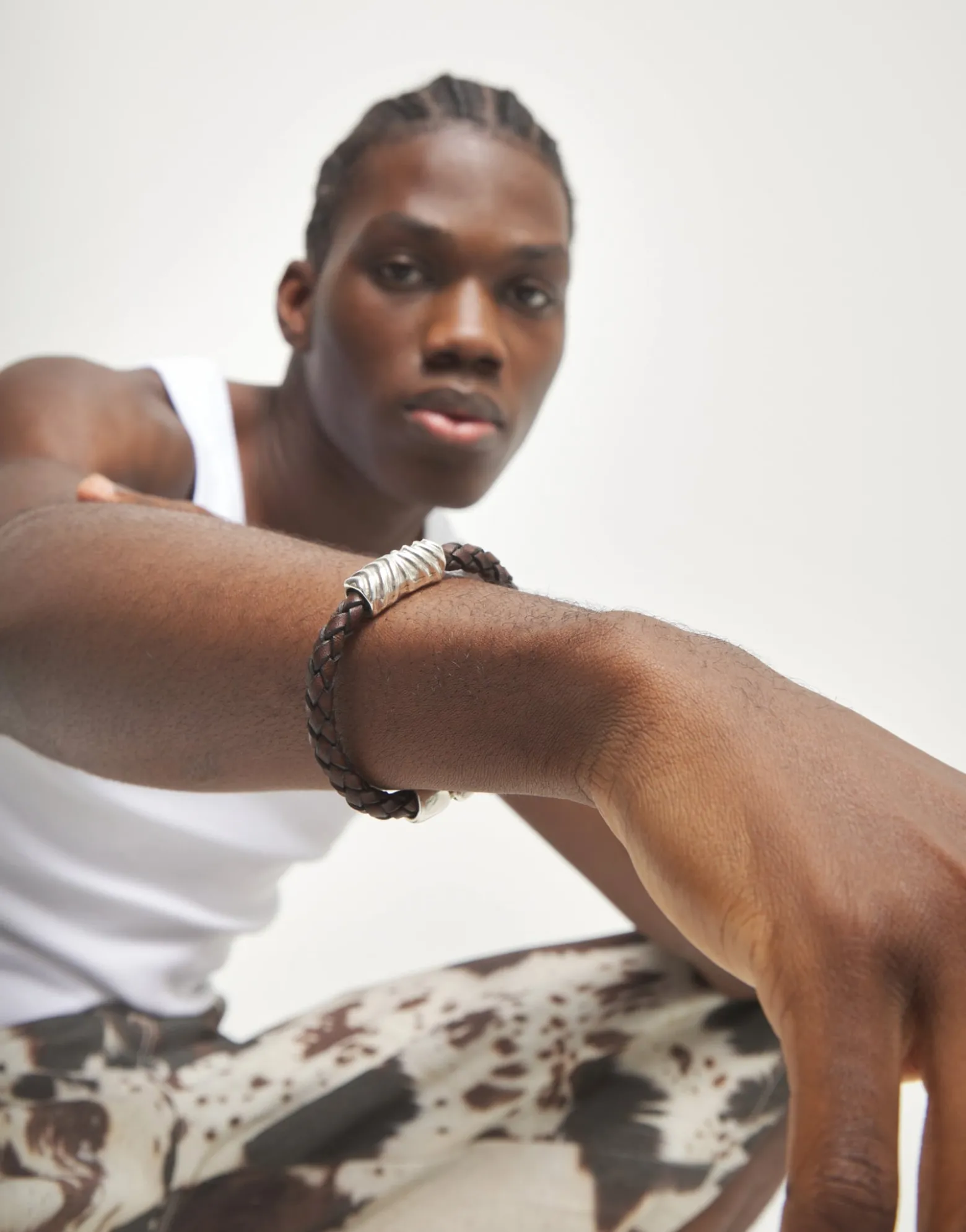 Brown braided leather bracelet with a metal detail