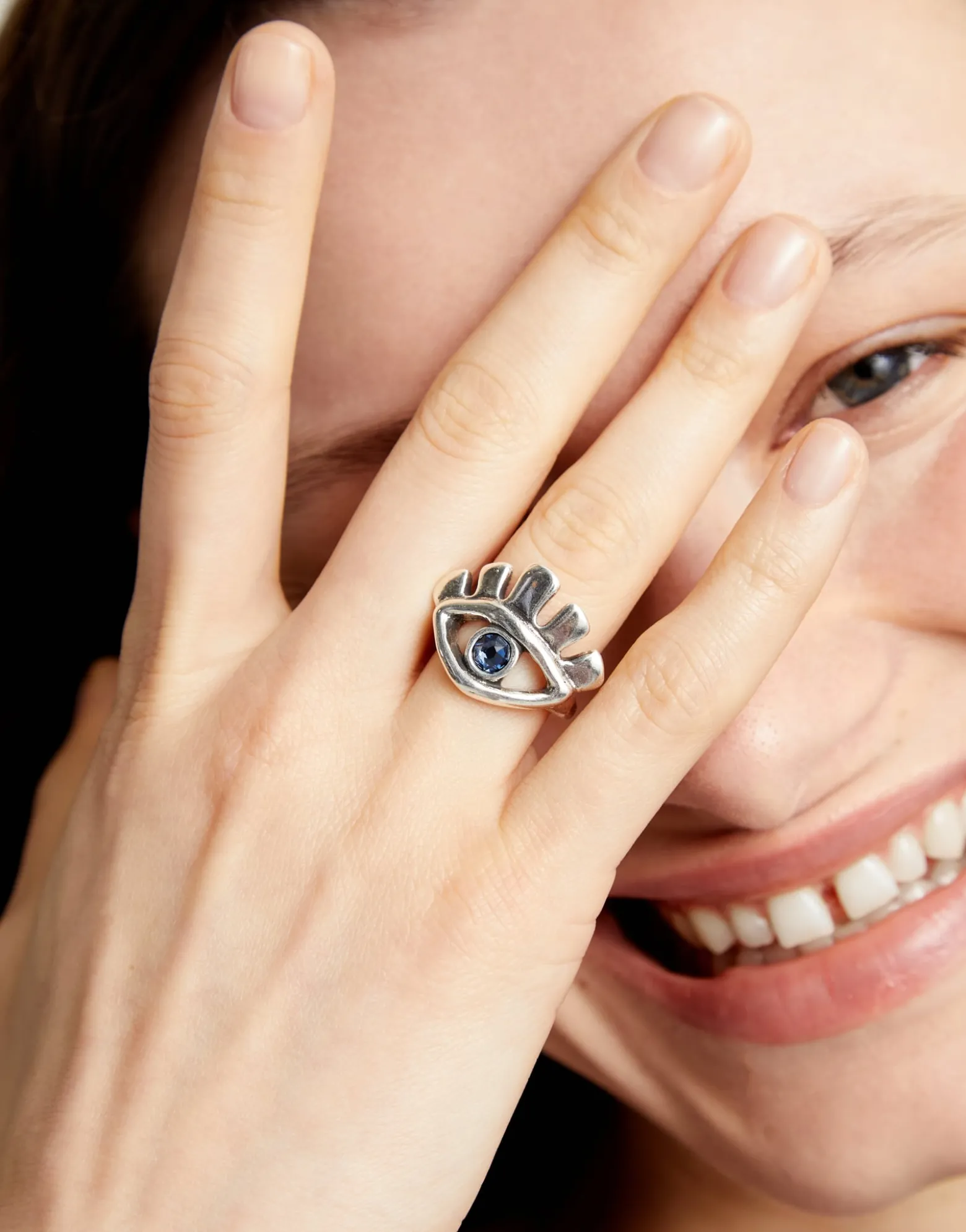 Eye-shaped ring with faceted blue crystal